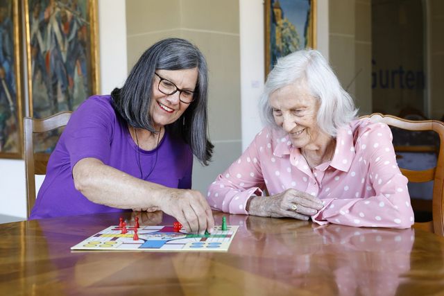 Eine Freiwillige spielt mit einer Bewohnerin 
